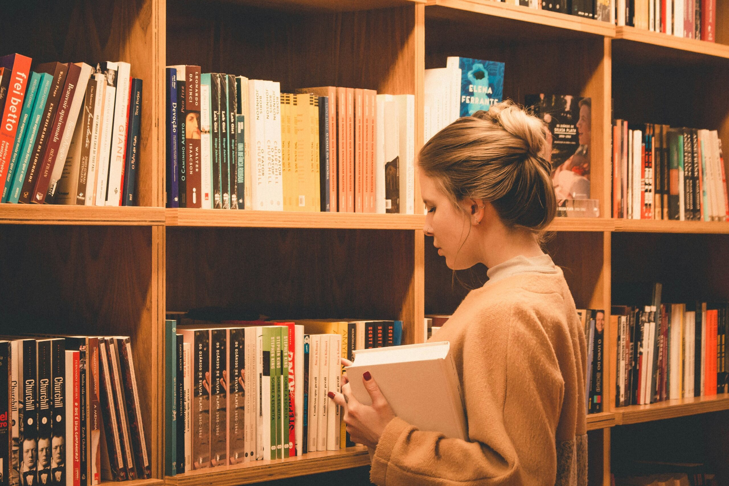 Bella sitting proudly next to a bookshelf.