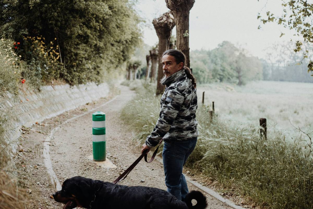 A trainer hiding a treat for a dog during scent-based training.